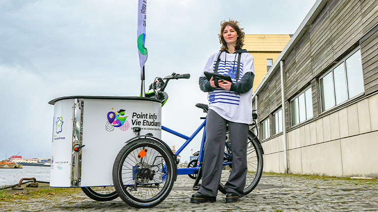 Photo d'un vélo cargo Point info vie étudiante avec une étudiante