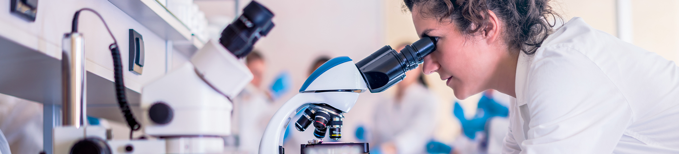 Photo d'une étudiante en biologie regardant dans un microscope