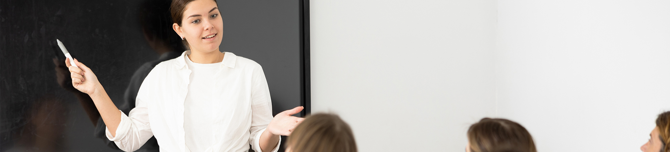 Photo d'une jeune professeure devant sa classe