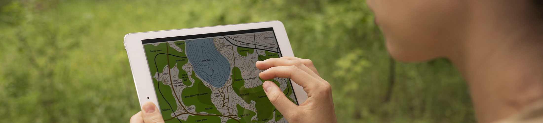 Photo d'une étudiante dans la nature travaillant sur une tablette