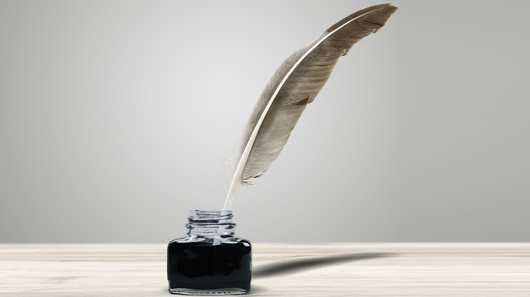 Photo d'une plume d'écriture dans un encrier